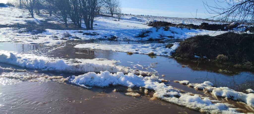 В деревне под Минском дорогу затопило водой с полей